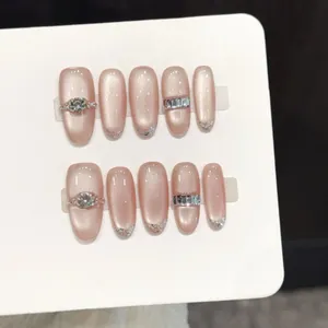 Unghie finte occhio di gatto rosa nude con strass e sfumatura glitter French