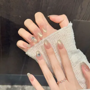 Nude pink cat eye press-on nails with champagne gradient and large rhinestone accents