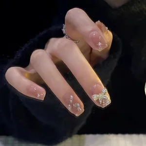 Détails d'ongles à presser avec perles, nœud 3D et paillettes sur fini rose brillant