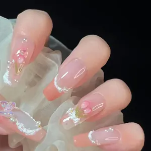 Détail de faux ongles rose dégradé avec papillon 3D, tulipes et accents de perles