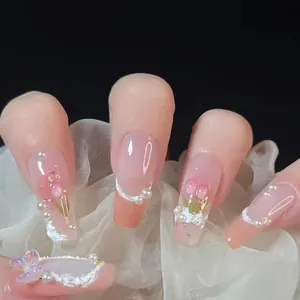 Détails d'ongles roses tulipe avec perles 3D et papillon sur un tissu blanc léger