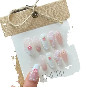 Pink gradient long coffin press-on nails with 3D floral accents, pearls, and silver glitter