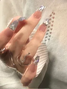 Detailed view of sea blue heart press-on nails with 3D silver snake ring decor