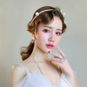 Close-up of bridal headband with pearls, tassels earrings and butterfly ring
