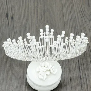 Detailed top view of a silver bridal tiara with pearls and rhinestones on a rose base