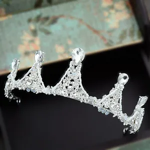 Detailed view of a silver bridal tiara featuring teardrop crystals and white beads