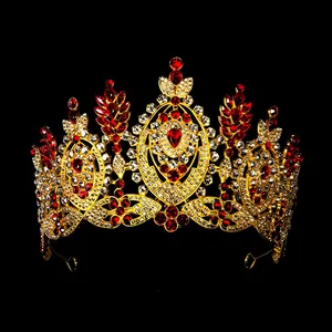 Close-up of golden bridal crown with red pear-cut crystals and sparkling white rhinestones
