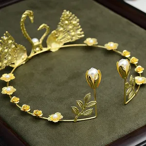 Detail eines goldenen Schwanen-Haarreifs mit Blumen und weißen Perlen auf Samt