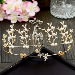 Detailed view of a golden elk crown with white faux pearls and branches for cake toppers