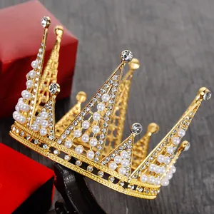 Dettaglio di una corona da sposa dorata con perle e strass su un supporto da esposizione