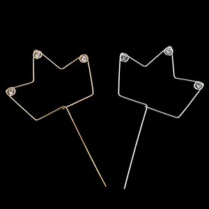 Macro detail of gold and silver crown cake toppers with sparkling crystal rhinestones