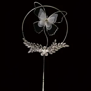 Detail of silver wrought iron cake topper with mesh butterfly and pearl rhinestones