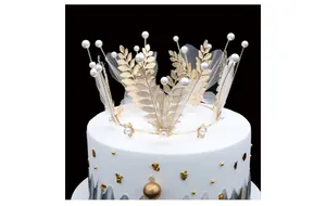 Macro detail of golden bridal crown with pearls and white tulle on a cake display