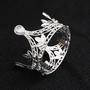 Macro detail of silver leaf tiara crown with sparkling crystals on black background