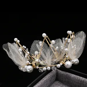 Macro shot of elegant gold wire crown with white pearls and translucent mesh wings