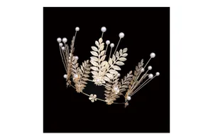 Detail of golden leaf crown with delicate white pearls for wedding or cake decor