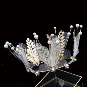 Elegant gold bridal crown with delicate metal leaves, white pearls and mesh veil accents