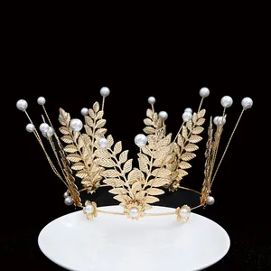 Elegant golden leaf crown tiara with white pearls on a minimalist ceramic plate