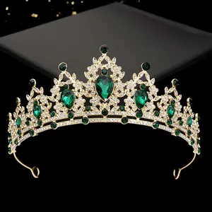 Macro view of golden bridal tiara with emerald green stones and sparkling rhinestones