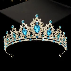 Detail of gold tiara featuring blue teardrop rhinestones and sparkling crystals