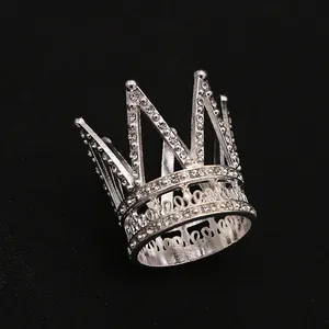 Macro shot of silver mini crown cake topper with sparkling rhinestones on black background