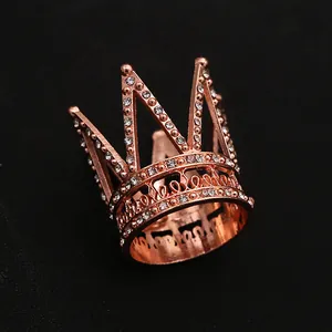 Macro shot of mini rose gold crown cake topper with rhinestones and hollow patterns