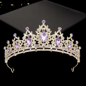 Detailed close-up of a gold-plated crown with purple teardrop gems and white rhinestones