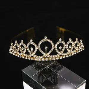 Macro detail of golden crystal crown with white rhinestones and side combs on black background