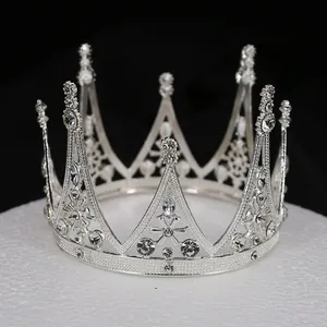 Gros plan d'une couronne baroque argentée ornée de cristaux sur un fond noir sobre
