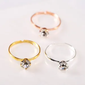 Dettaglio di fedi nuziali regolabili in oro, argento e oro rosa con pietre trasparenti