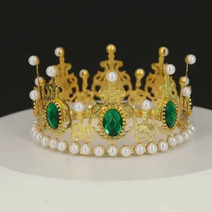Detailansicht einer goldenen Krone mit weißen Perlen und einem großen grünen Edelstein