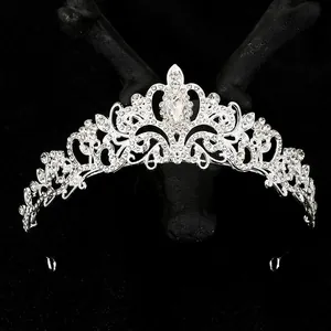 Silver bridal tiara with sparkling rhinestones and drop-shaped crystal on black display