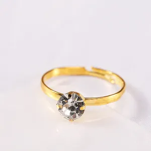 Dettaglio di un anello placcato oro regolabile con zircone rotondo lucido a quattro griffe