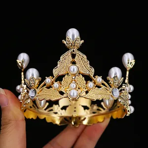 Detail of baroque gold crown with white pearls and sparkling rhinestones on black background