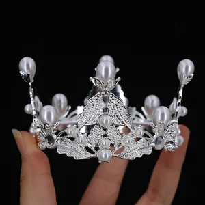 Elegant silver bridal crown featuring sparkling rhinestones and white pearls for cake or hair