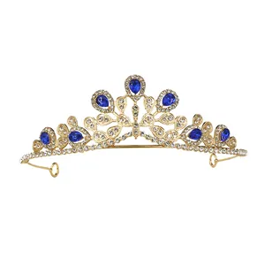 Detailopname van de gouden kroon met blauwe kristallen druppels en witte strassteentjes