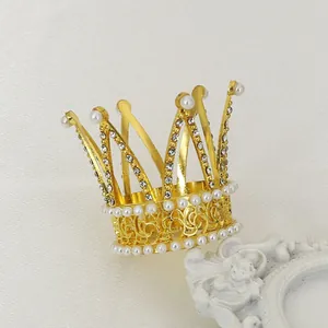 Macro detail of a golden mini crown with pearls and rhinestones on a decorative pedestal