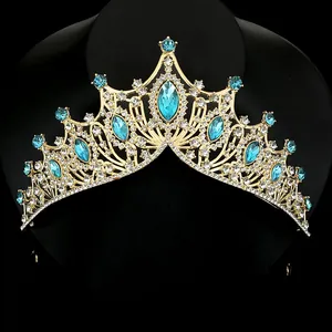Elegant gold bridal crown with blue sapphire crystals and white rhinestones on black stand
