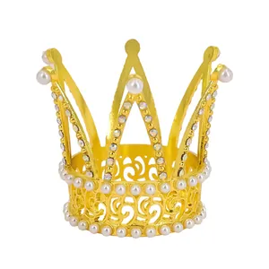 Detailed close-up of a golden crown cake topper with white pearls and sparkling rhinestones