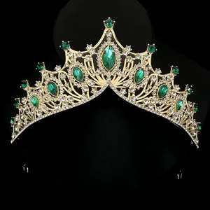 Elegant gold bridal crown with emerald crystals and white rhinestones on black background