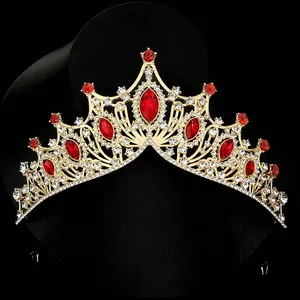 Macro detail of golden baroque bridal crown with red gems and sparkling crystals