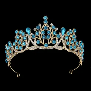 Macro view of gold baroque bridal crown with blue rhinestones on black background