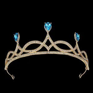 Detailed view of luxury gold crown with blue teardrop rhinestones and pavé crystals