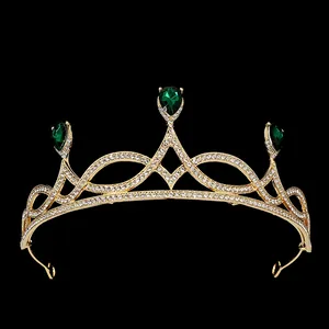 Detailed close-up of golden bridal tiara with green teardrop gems and white crystals
