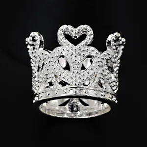 Detailed macro view of a silver crown cake topper ring with heart and crystal accents
