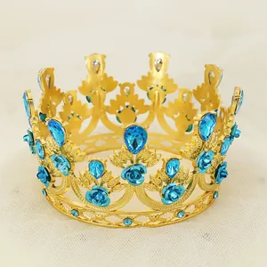 Detail of golden crown with blue rhinestones and 3D roses on a white tulle background