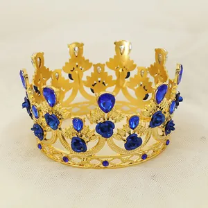 Close-up of golden crown featuring blue roses, teardrop gems, and heart-shaped cutouts