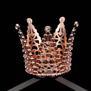 Rose gold round crown decoration with sparkling rhinestones on a reflective black background