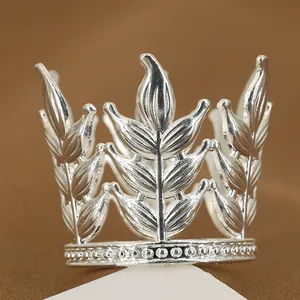 Corona d'argento con motivi a foglia e dettagli di perline su sfondo scuro