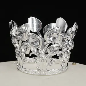 Detailed close-up of a silver metal crown with crystal rhinestones on a black background